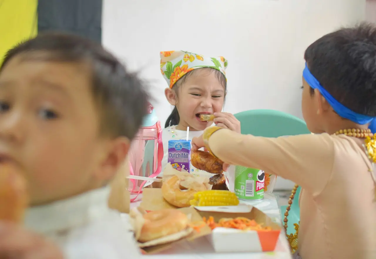 Niños comiendo en la mesa de la escuela infantil